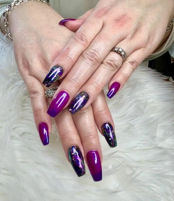 Coffin nails in magenta and purple with glitter accents.